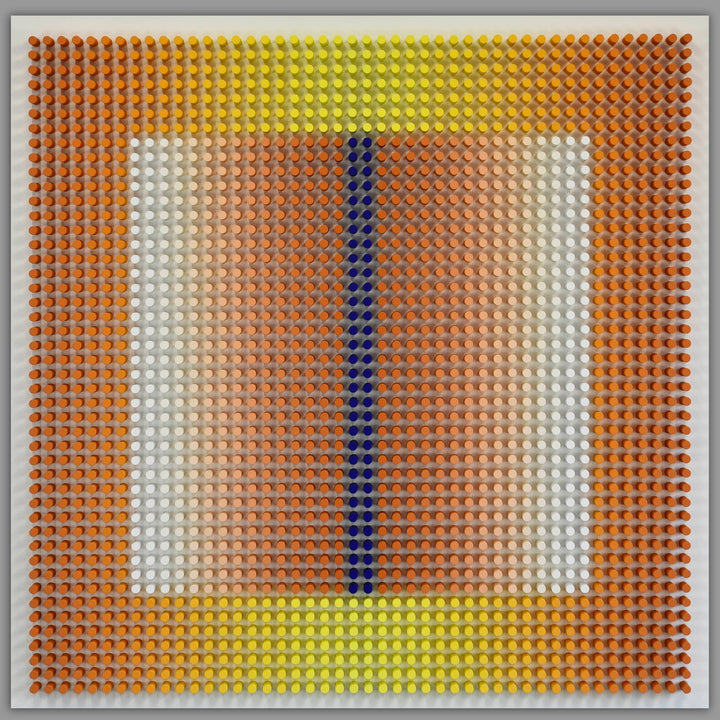 Artistic wall piece made of interlocking bricks on a gray background